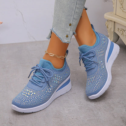 Scarpe da ginnastica blu con dettagli brillanti, suola bianca, indossate con jeans chiari. Scarpe sportive eleganti per donna, moda casual.