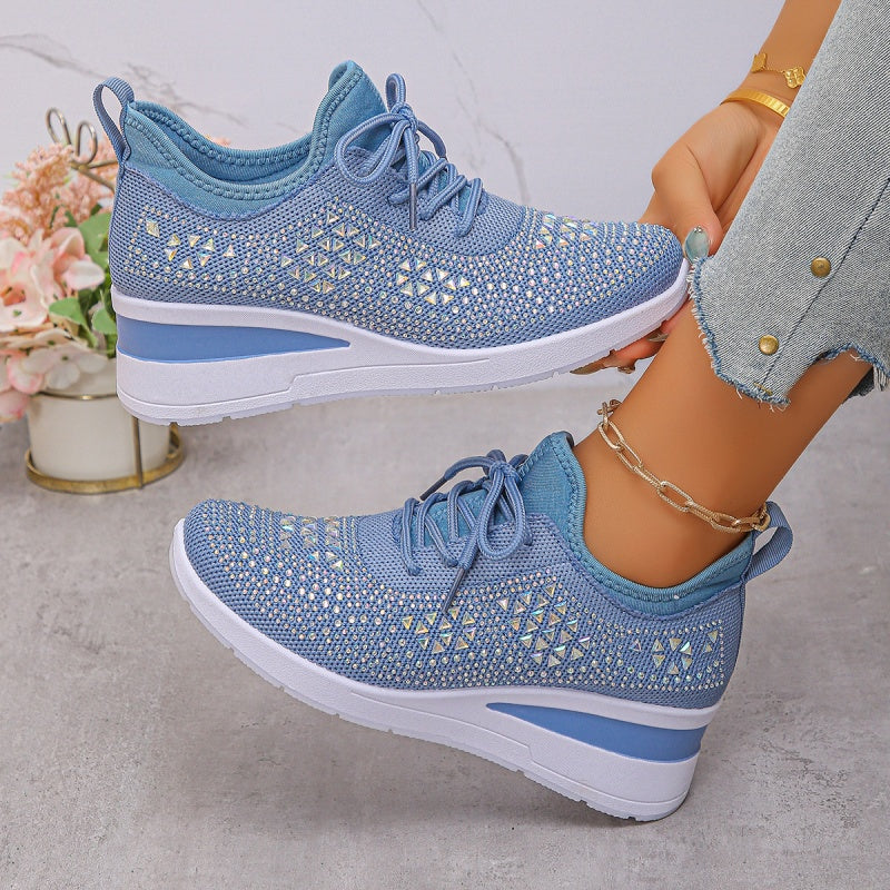 Scarpe da ginnastica blu in maglia traspirante, suola bianca, indossate con jeans. Design moderno e confortevole, perfette per attività sportive.