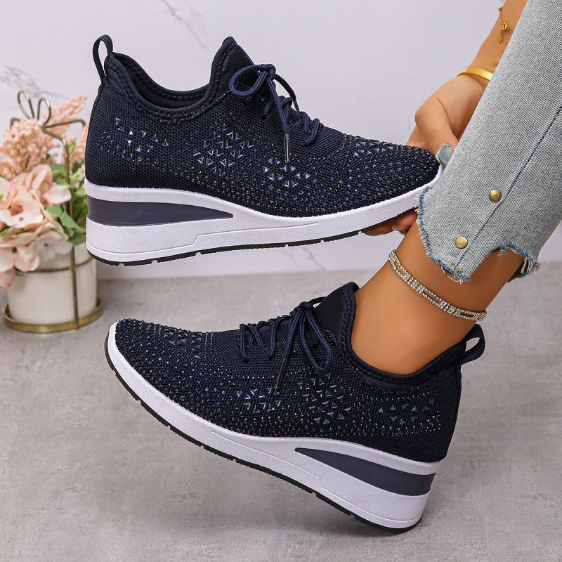 Scarpe da ginnastica blu scuro con zeppa, design traforato, indossate con jeans chiari. Moda casual donna, calzature comode e trendy.