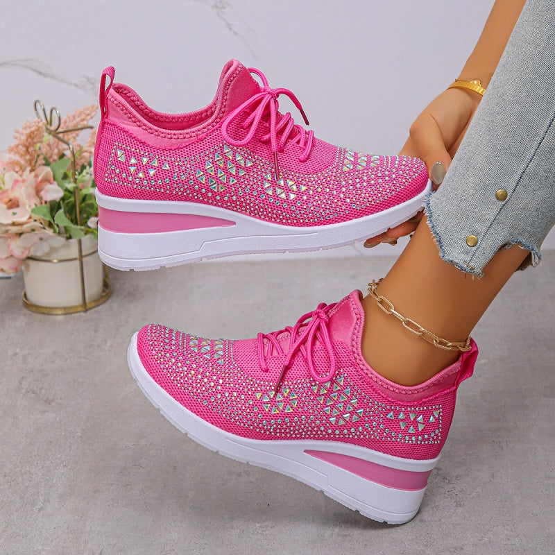 Scarpe da ginnastica rosa con dettagli geometrici, suola bianca, indossate con jeans chiari. Scarpe sportive moda donna, stile casual.
