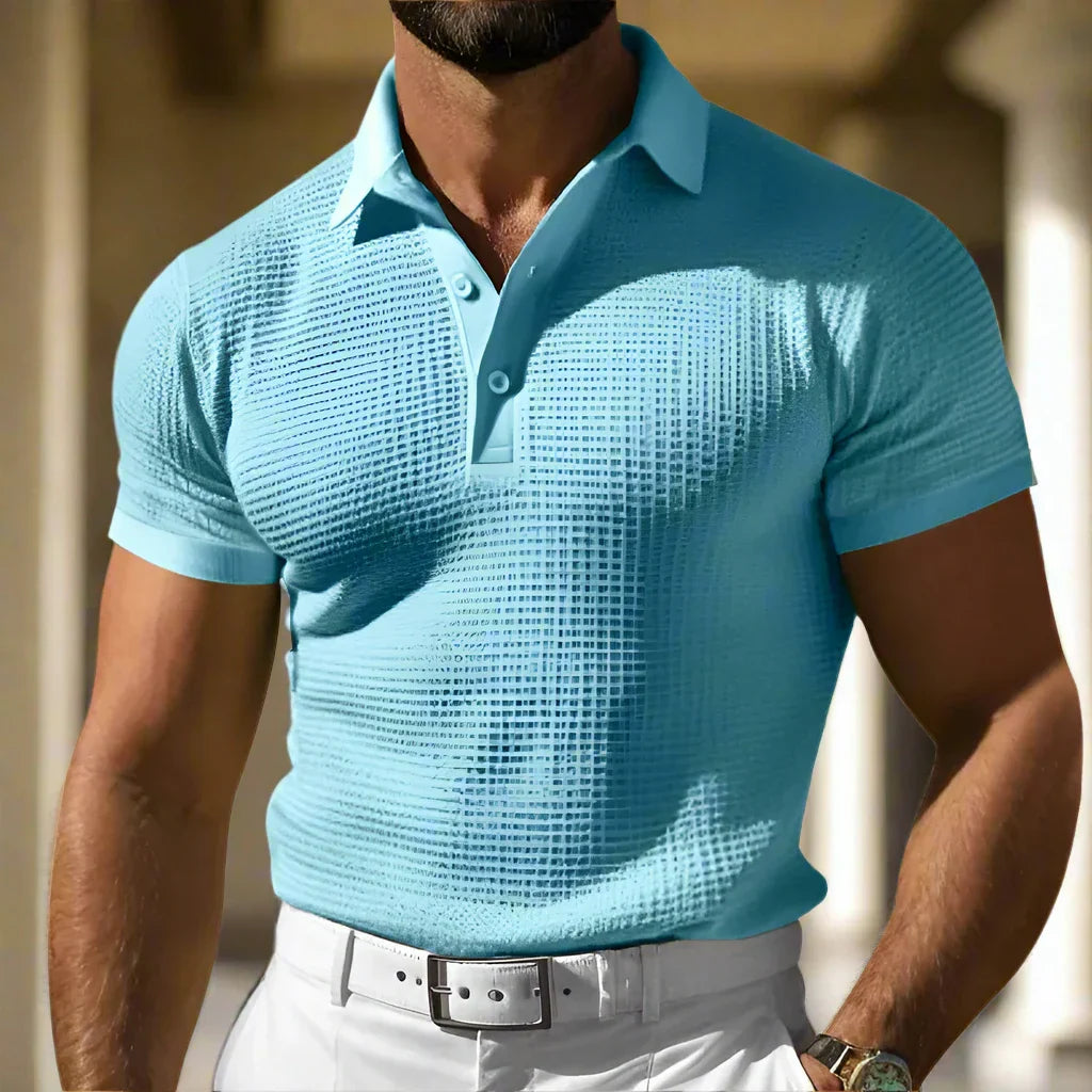 Uomo in polo azzurra a trama, pantaloni bianchi e cintura grigia. Moda estiva maschile, abbigliamento casual elegante.