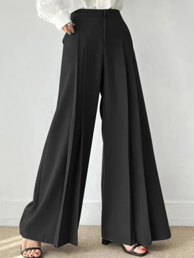 Pantaloni palazzo neri eleganti, tessuto fluido, vita alta, abbinati a camicia bianca. Moda donna, abbigliamento formale, stile sofisticato.