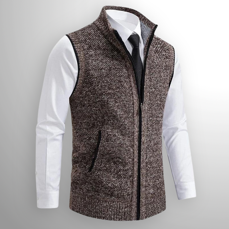 Gilet in maglia marrone con zip, indossato sopra camicia bianca e cravatta nera. Moda uomo elegante, abbigliamento autunnale, stile casual chic.