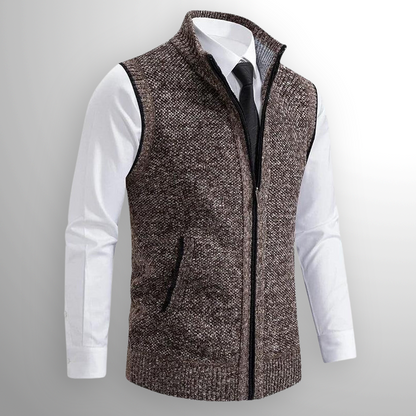Gilet in maglia marrone con zip, indossato sopra camicia bianca e cravatta nera. Moda uomo elegante, abbigliamento autunnale, stile casual chic.
