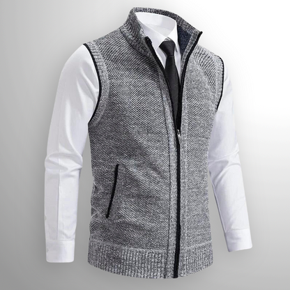Gilet grigio in maglia con zip, indossato sopra camicia bianca e cravatta nera. Moda uomo elegante, abbigliamento casual chic.