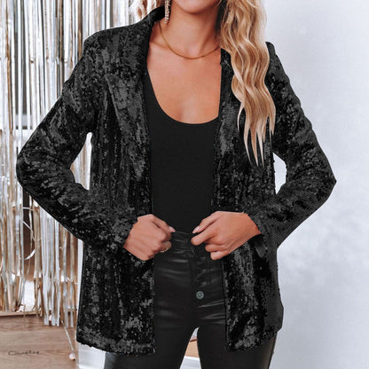 Donna con giacca di paillettes nere, top nero e pantaloni in pelle, sfondo con decorazioni argentate. Moda elegante, abbigliamento da festa.