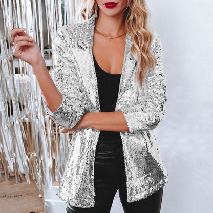 Donna con giacca di paillettes argento, top nero e pantaloni in pelle. Moda elegante, abbigliamento da festa, stile glamour.