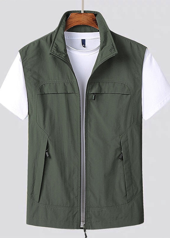 Gilet verde militare da uomo con zip, tasche multiple e colletto alto, indossato sopra una maglietta bianca. Moda casual, abbigliamento outdoor.