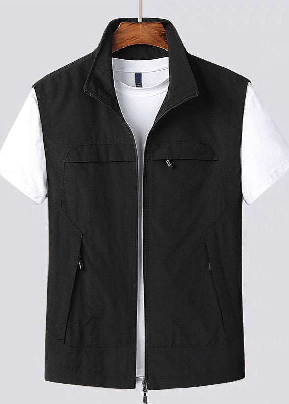 Gilet nero senza maniche su t-shirt bianca, appeso su gruccia. Moda casual uomo, abbigliamento estivo, stile versatile.