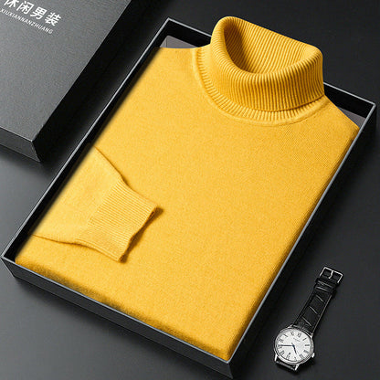Maglione giallo a collo alto in scatola regalo nera, orologio da polso elegante accanto. Maglione invernale uomo, moda casual, abbigliamento caldo.