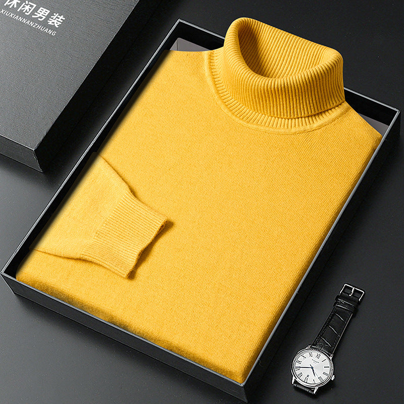 Maglione dolcevita giallo in lana, confezionato in elegante scatola nera, accanto a orologio da polso. Moda uomo, abbigliamento invernale.