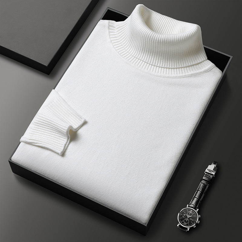 Maglione dolcevita bianco in lana, elegante e piegato in scatola nera, accanto a orologio da polso in acciaio su sfondo grigio scuro.
