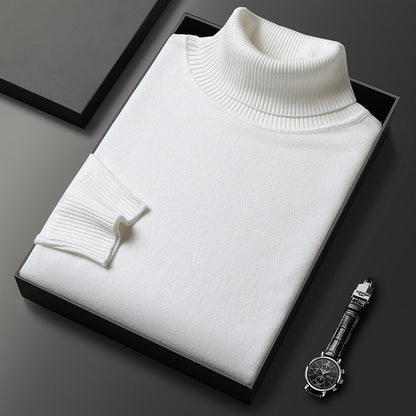 Maglione dolcevita bianco in lana, elegante e piegato in scatola nera, accanto a orologio da polso in acciaio su sfondo grigio scuro.