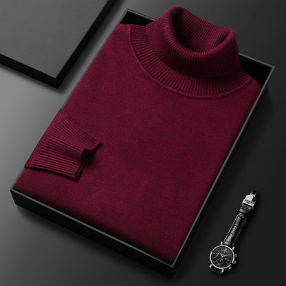 Maglione dolcevita bordeaux in lana, piegato in scatola nera su sfondo scuro, accanto a orologio da polso elegante. Moda uomo, abbigliamento invernale.
